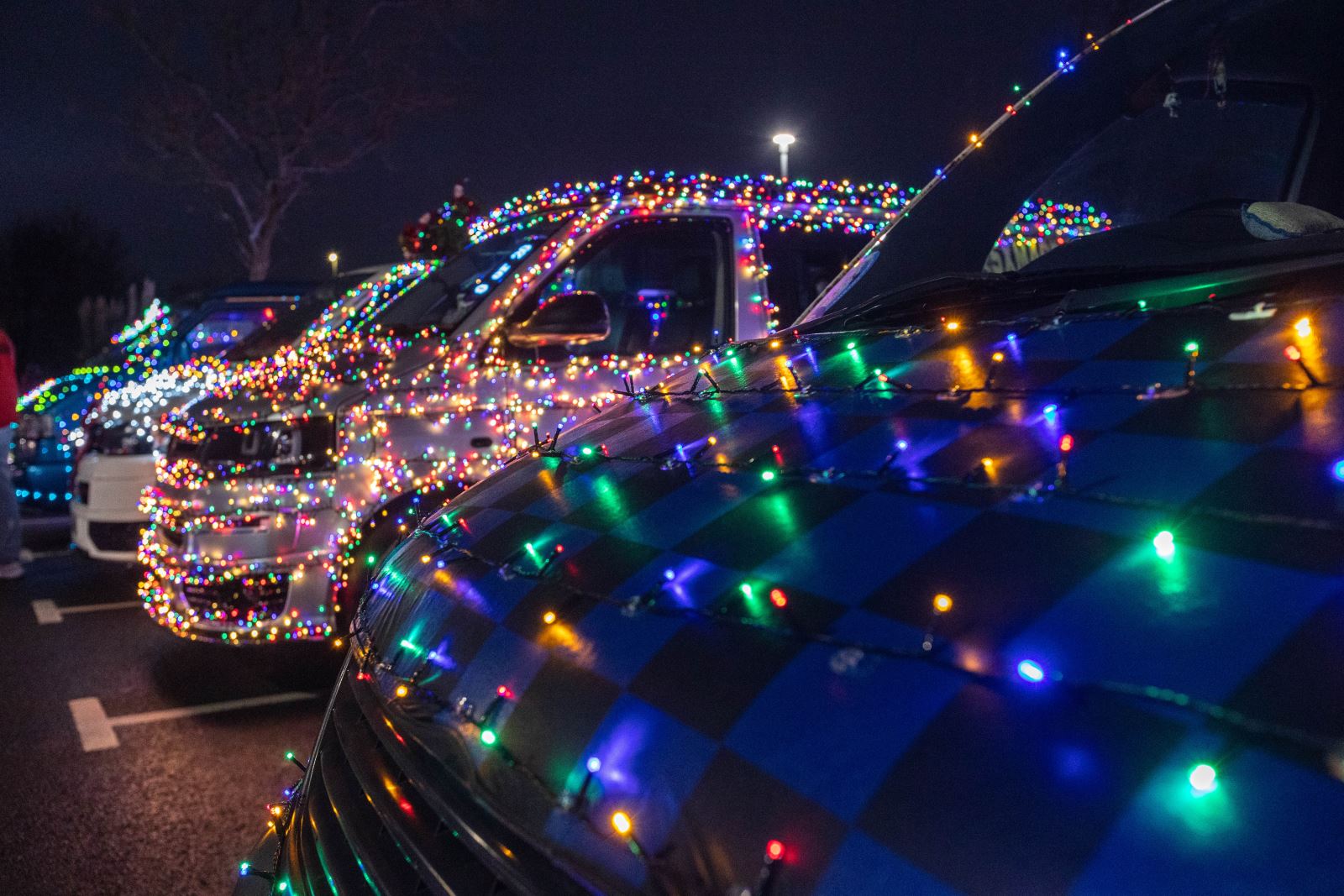 Two VW vans decorated in Christmas lights at the Weston-super-Mare Vee Dubs Christmas Cruz