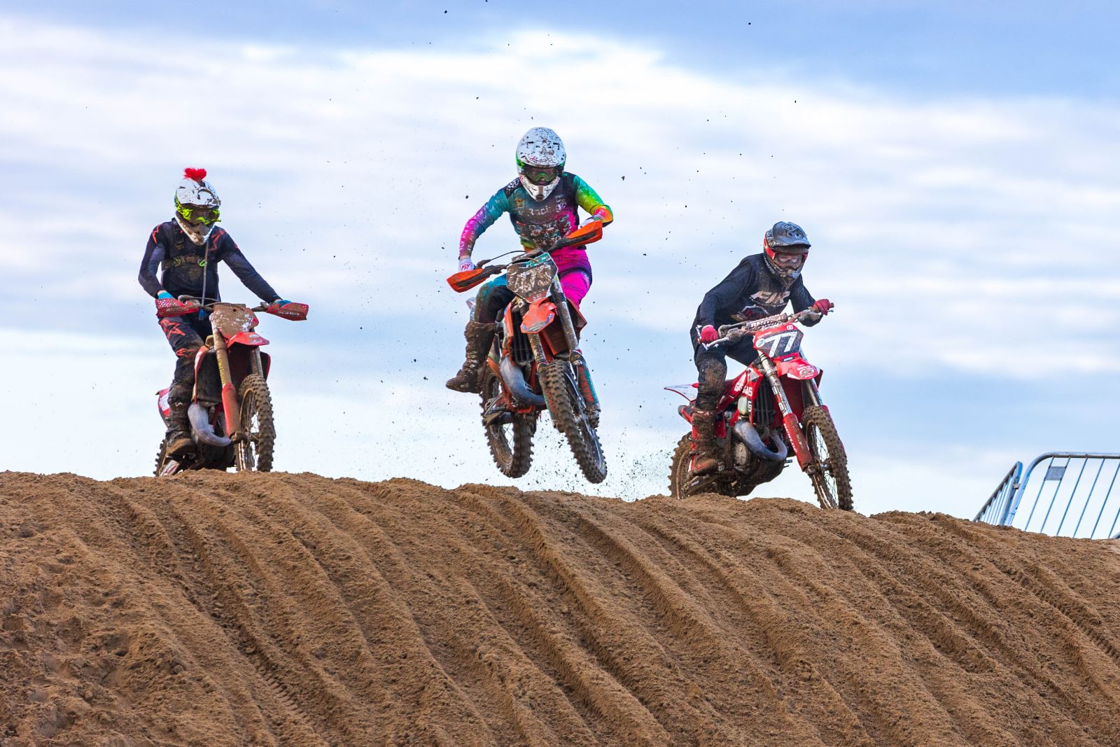 Three moto cross riders at the top of a sand dune at the Weston-super-Mare Beach Race