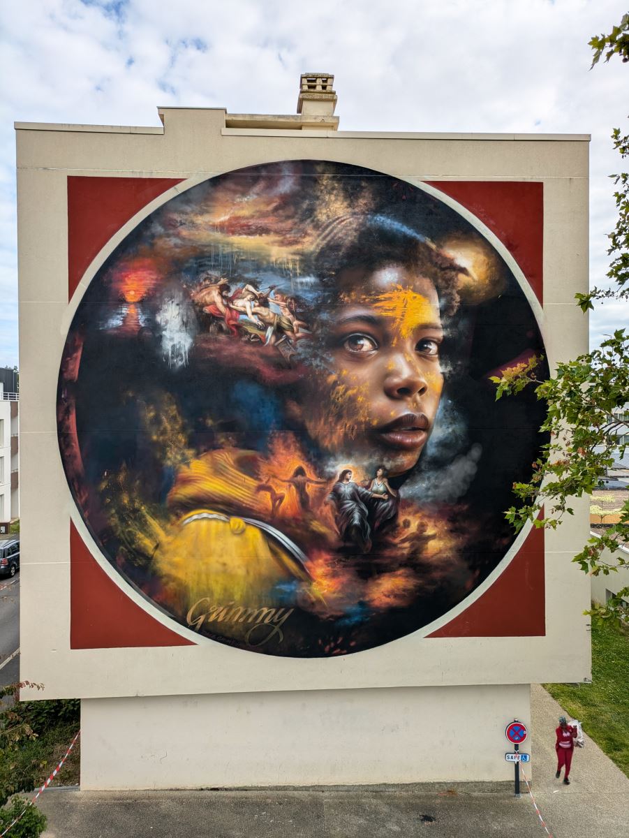 A Dale Grimshaw giant street art mural featuring a dominant face surrounded by other characters in scenes